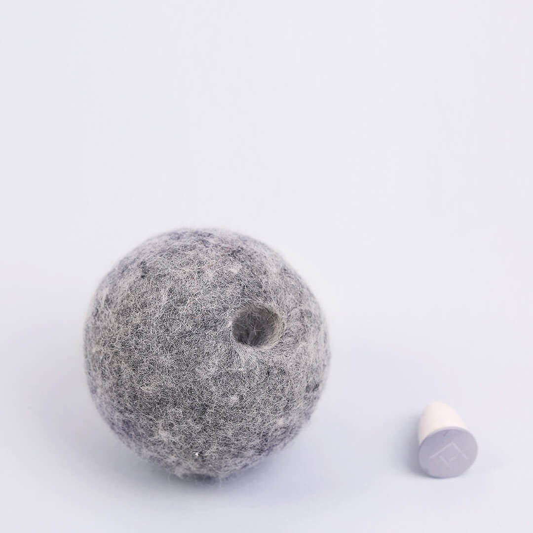 Cat playing with wool catnip capsule toy